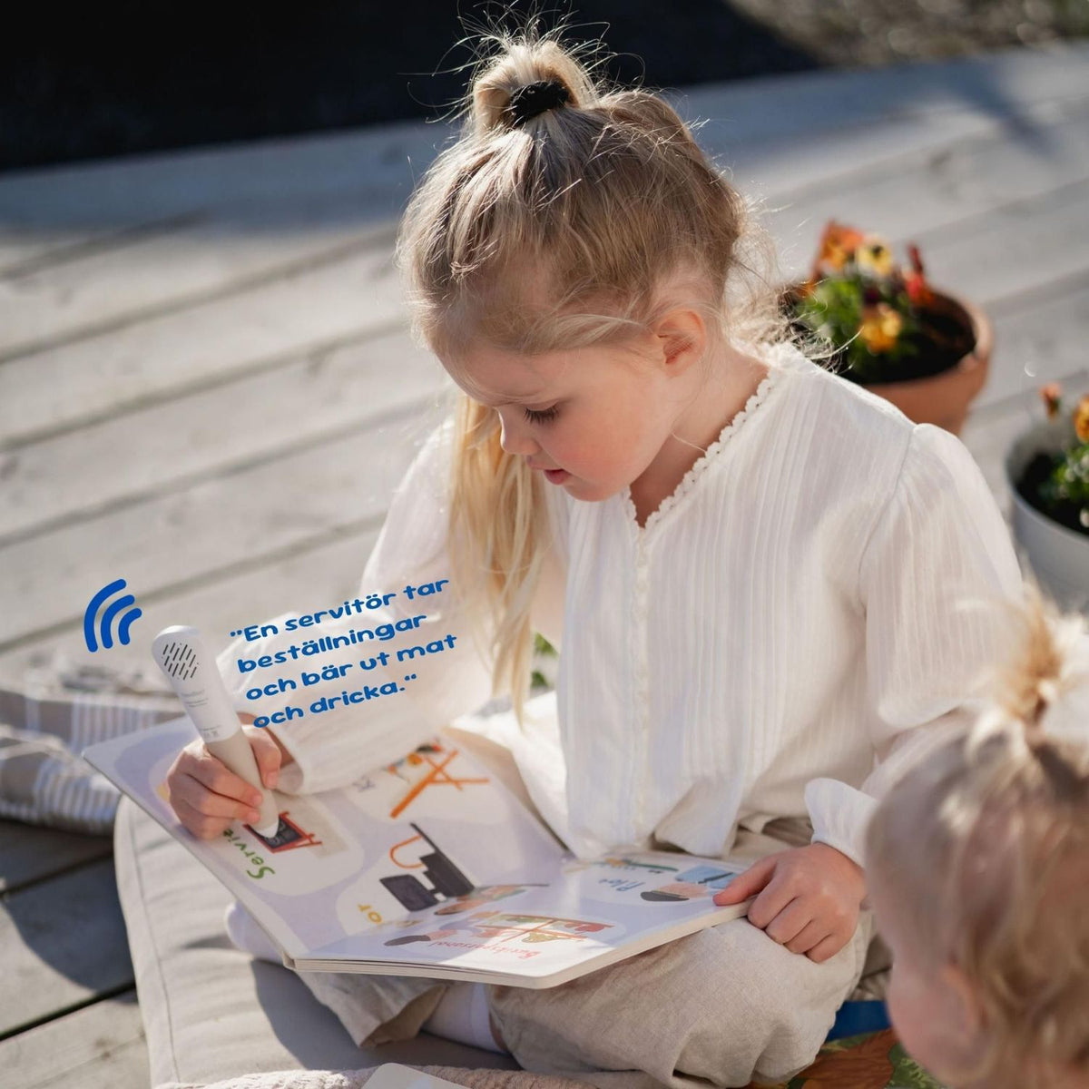 Barn använder Readioo läspenna i boken Alla möjliga yrken och lyssnar på en sida om yrken.
