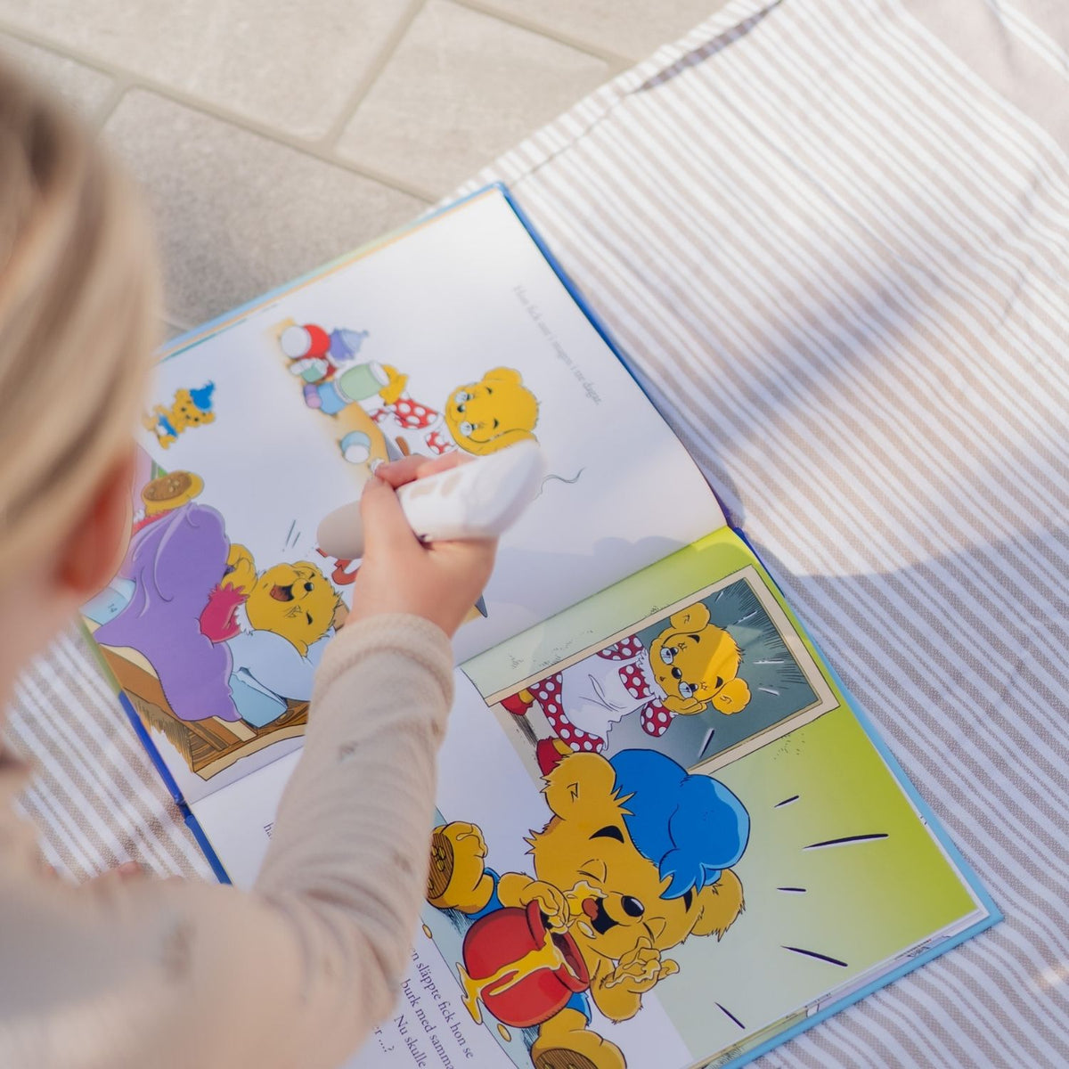 Uppslag ur Bamse och Brummelisa med tydliga illustrationer och interaktivt stöd för språkutveckling