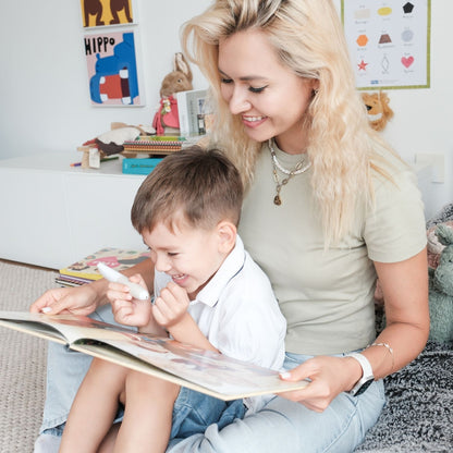 Mamma och barn läser en bok tillsammans och använder Readioo läspenna.