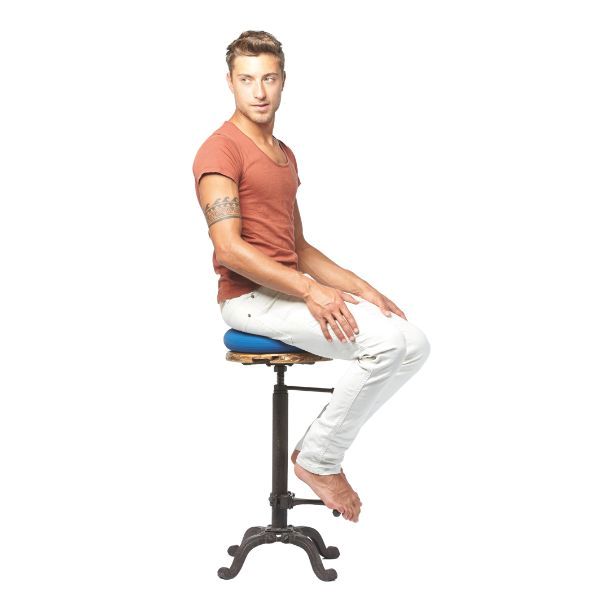 Man sitter på blå Dynair sittkudde på en industriell stol.