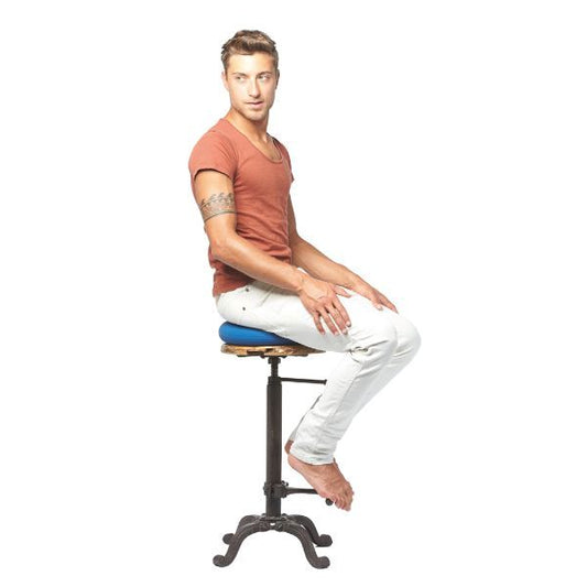 Man sitter på blå Dynair sittkudde på en industriell stol.