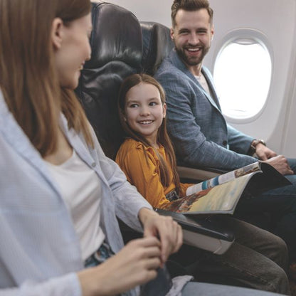  Leende familj med barn sitter bekvämt i flygplan – hörselskydd skapar en lugnare resa.