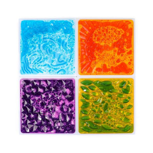 Fyra sensoriska golvplattor med färgad vätska och 3D-struktur i blått, orange, lila och grönt