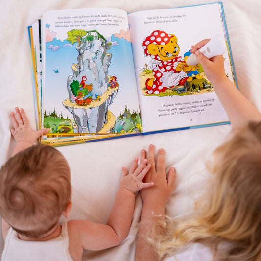 Två barn upplever boken Bamse och Hoppa-Tossa interaktivt med Readioo läspenna