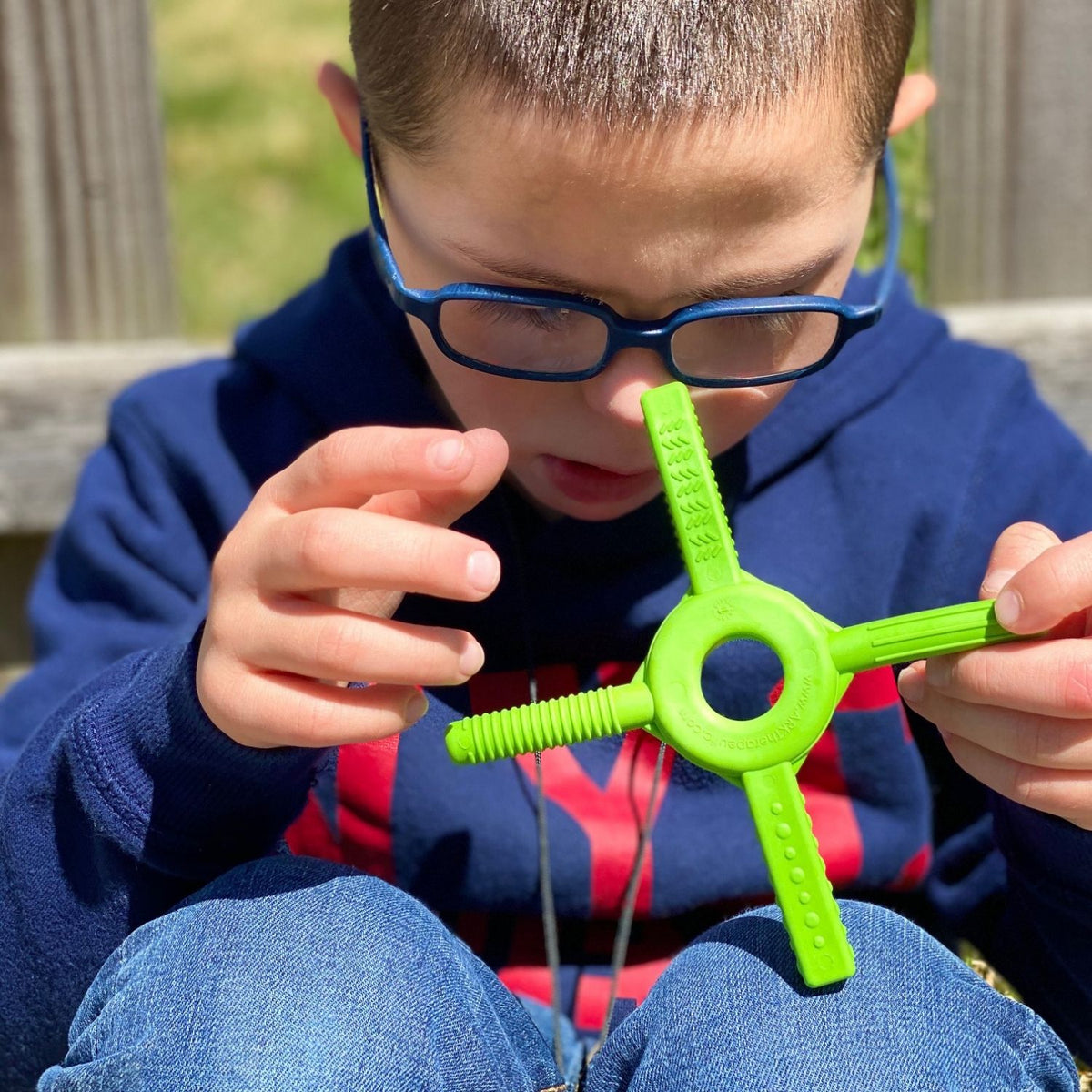 Pojke snurrar Tetra-Bite Fidget mellan händerna, använder den som handfidget.