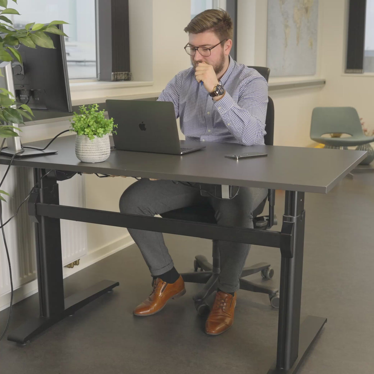Video av en man på kontoret som går från rastlöshet med skakande ben och fötter till lugn och fokus med hjälp av SWNX Office-fotgunga under skrivbordet.