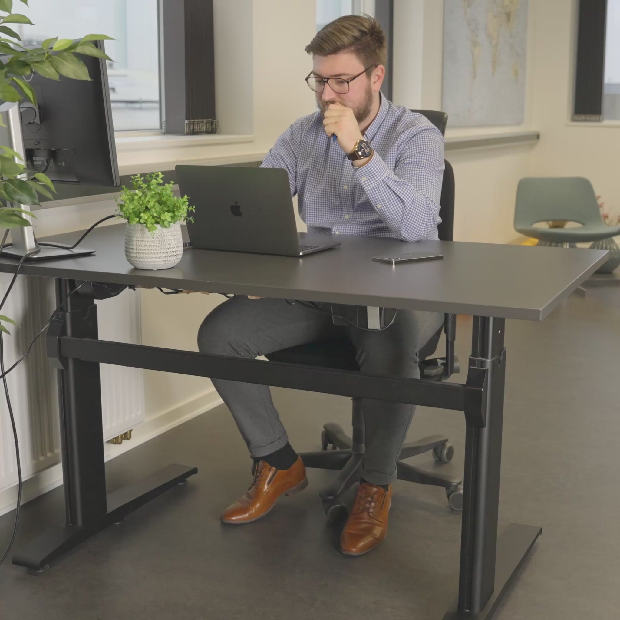 Video av en man på kontoret som går från rastlöshet med skakande ben och fötter till lugn och fokus med hjälp av SWNX Office-fotgunga under skrivbordet.