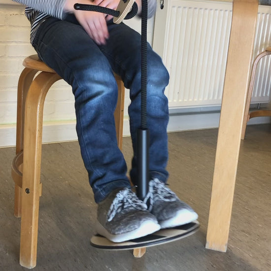 Barn använder SWNX Mini Original fotgunga medan han skriver i sin bok, för bättre fokus och lugn.