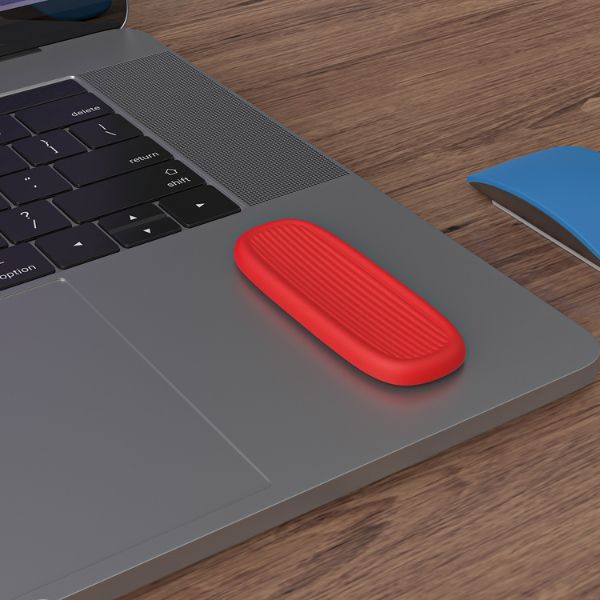 Röd relax bar fastsatt på en laptop, visar hur produkten kan användas på släta ytor.