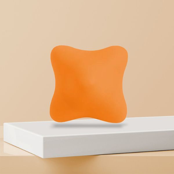 Sensorisk greppboll i orange silikon på vit display med mjuk bakgrund