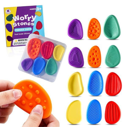 Hand trycker på orange sensorisk sten med upphöjda bubblor
