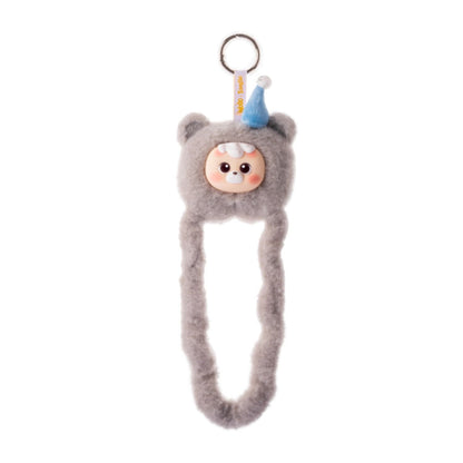 Grå Tangle x HiddenWooo Mallow Bears Sesame Snow med blå partyhatt, fluffig plysch och metallring för upphängning.