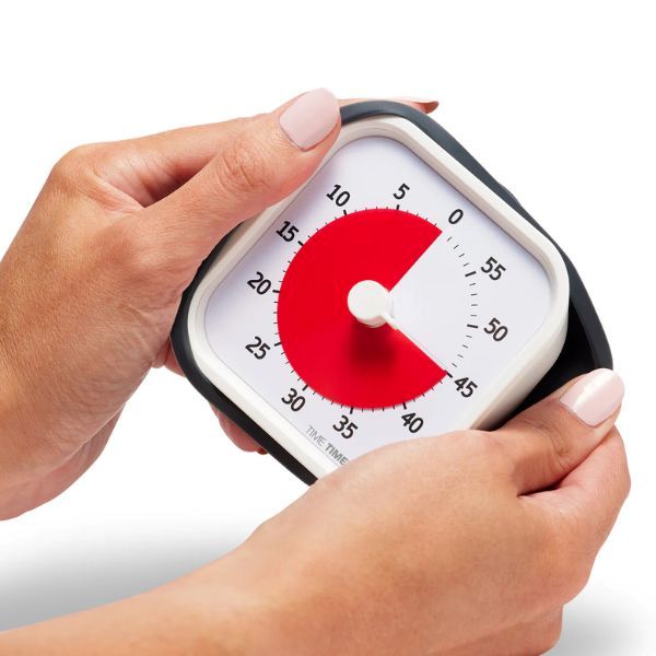 Händer håller Time Timer MOD för att visa dess bärbara och praktiska storlek.