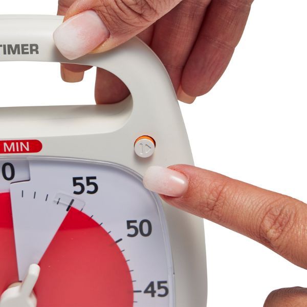Närbild på hand som trycker på pausknappen på Time Timer Plus vit modell.