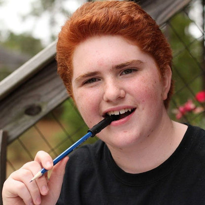 Pojke tuggar lugnande på Bite Saber penntopp, effektivt ADHD-hjälpmedel i skolan.